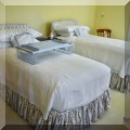 F36. Pair of twin beds with upholstered headboards and matching skirts. 